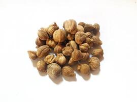 Dried cardamom, as a complementary spice in cooking seasonings, flat lay shot and isolated on white background. photo