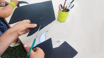 Top view close up of toddler boy hands, kid creating paper birds. Fun arts and crafts for toddlers, Kids art project photo