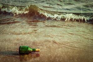 Message bottle on beach in waves photo