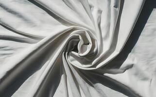 A photo of a white fabric on a white background with sunlight reflecting off the folds.