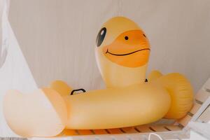 Inflatable duckling, summer - Bright yellow floatation device enhances swimming experience and safety ensured for young swimmers on warm summer days. photo
