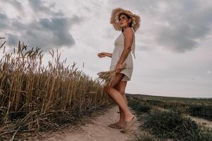 Woman in a Straw Hat Walking Through a Wheat Field photo