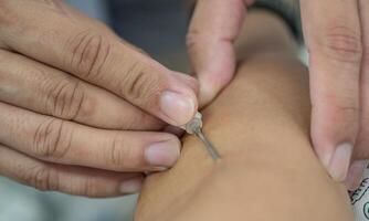 Cropped shot view of healthcare worker while inject butterfly needle into arm for draw blood from donor. photo