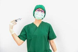 Portrait of young surgery nurse or doctor acting madness and trying to injecting herself with a syringe into a blood vessel at her neck. Healthcare worker and Medical concept. photo