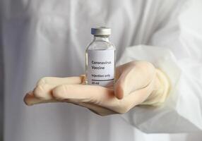 Close up of scientist doctor hand holding a sample test bottle of Covid-19 vaccine. photo