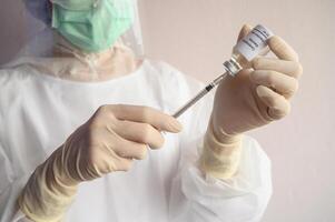 Scientist doctor hand holding syringe with a sample test bottle of Covid-19 vaccine. photo