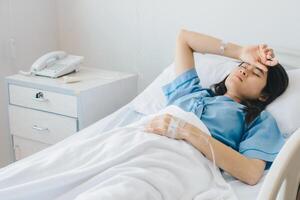 Portrait of sickness patient woman lying on hospital bed, resting for recovery. Conceptual of sickness woman feeling when admitted in the hospital. photo