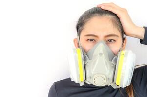 Portrait of young Asian woman wearing gas mask for protect smog bad air pollution or toxic. Air pollution has been associated with diseases of the heart and lungs, cancers and other health problems. photo