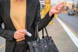 Cropped shot of business woman keeping hand sanitizer in her bag, an important item in pandemic situations. photo