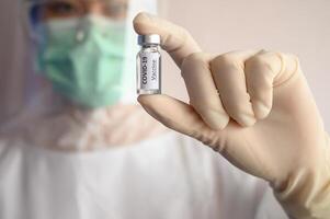 Scientist doctor holding a sample test bottle of Covid-19 vaccine. photo