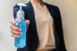 Close up of woman holding a hand sanitizer before using it. photo