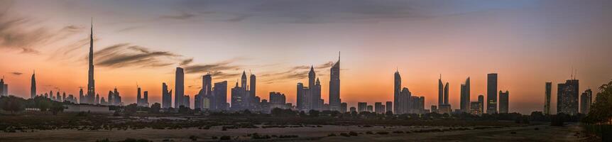 Panoramic image of the illuminated skyline of Dubai at dusk after sunset photo