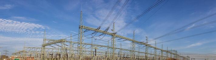 Panoramic view of a transformer station with insulators and cables photo