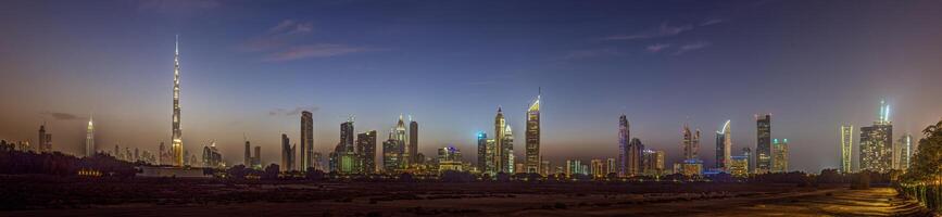 Panoramic image of the illuminated skyline of Dubai at dusk after sunset photo
