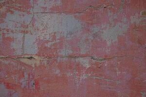 Aged and cracked textured surface. Weathered pink wall with cracks and patina. A great rustic vintage background for graphic design, web and digital art. photo