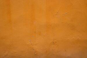 Closeup of an orange wall showcasing its texture and natural imperfections, perfect for background and design projects, Vertical mage shows urban decay with its rustic and vibrant elements photo