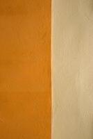 Vibrant orange wall texture with a subtle beige stripe, perfect for background, design inspiration or artistic project. Image of imperfections and unique details of an outdoor painted surface. photo