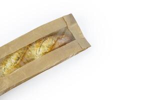 Freshly baked French baguette in a brown paper bag isolated on a white background.Loaf of white bread wrapped in eco-friendly sustainable brown paper bag. Copy space. With clipping path. photo