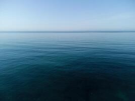 Aerial panoramic view of seascape with crystal clear azure sea and rocky shores. Yachts in a beautiful lagoon on backdrop of rocks. The concept of an ideal destination for summer travel and vacation. photo