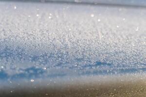 Selective focus. First frost on a frozen car, late autumn close-up. Beautiful abstract frozen microcosmos pattern. Freezing weather frost action in nature. Winter backdrop. photo