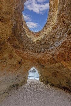 un hombre caminando dentro el Oceano mediante un apertura en el rocas foto