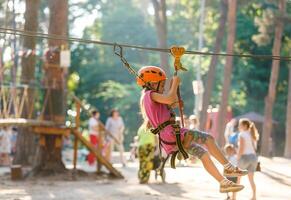 Smiling little girl on the playground, climbing rope net photo