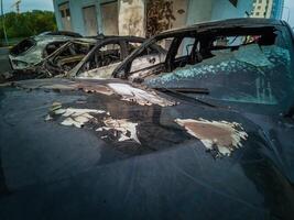 A cropped front view of a burned and abandoned rusty cars photo