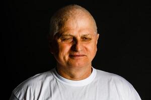 Portrait of happy retired senior man standing at home near window. Satisfied old man looking at camera and smiling while standing near the window. Positive and confident elderly enjoy his retirement photo