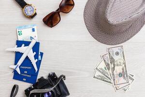 Travel preparation. A lot of objects are scattered on gray background - a camera, tickets, documents, a toy plane. Family holidays, holidays near the sea, holidays. photo