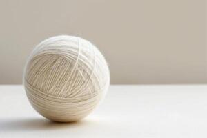 Ball of yarn resting on white surface photo