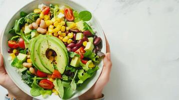 Freshly Prepared Colorful Salad With Avocado and Beans on a White Table photo