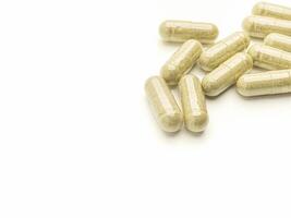 Flat lay of Andrographis Paniculata capsules isolated on white background. Space for text. Herbal, medicine, and healthcare concept photo