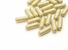 Flat lay of Andrographis paniculata capsules isolated on white background. Space for text. Herbal, medicine, and healthcare concept photo