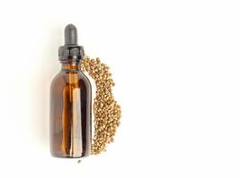 Medicinal cannabis with extract oil in a bottle and cannabis seeds isolated on white background. Space for text photo