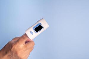 Close-up of woman finger with a pulse oximeter for testing oxygen levels on a white background. Measurement of oxygen level in the blood. Healthcare concept photo