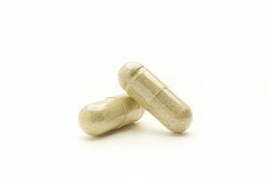 Close-up of Andrographis paniculata capsules placed isolated on white background. Space for text. Herbal, medicine, and healthcare concept photo