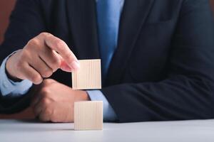 Hand of businessman arranging empty wooden blocks. Close-up photo. Space for text. Business and strategy planning concept photo