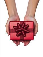 Woman holding a red gift with a bow on a white background photo