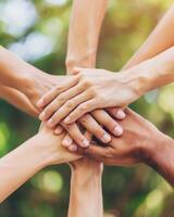 Team of businesspeople stacking hands showing unity and teamwork photo