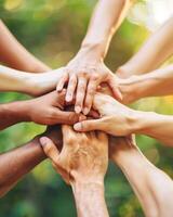 Diverse group of people joining hands in circle, symbol of teamwork and unity photo