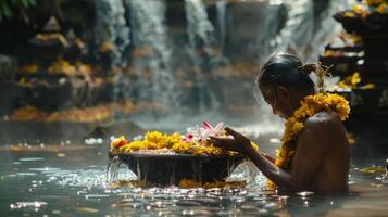 Elderly gentleman taking part in a spiritual purification ritual with water and flowers photo