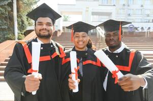 Diverse international students with diplomas at university campus photo