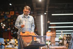 Senior man at grocery store products photo