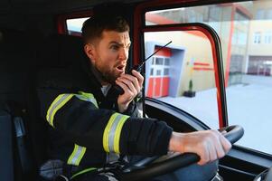 Firefighter using radio set while driving fire truck photo