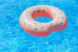 Inflatable swim ring in shape of donut floating in pool photo