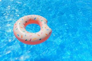 Inflatable swim ring in shape of donut floating in pool photo