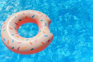Inflatable swim ring in shape of donut floating in pool photo