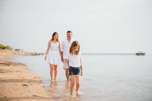 Happy family walking on the beach photo