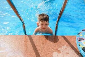 Happy child playing in swimming pool. Summer vacation concept photo