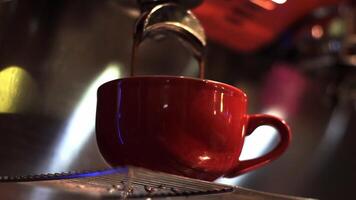 Close up footage of fresh espresso flows from coffee machine into a red cup video